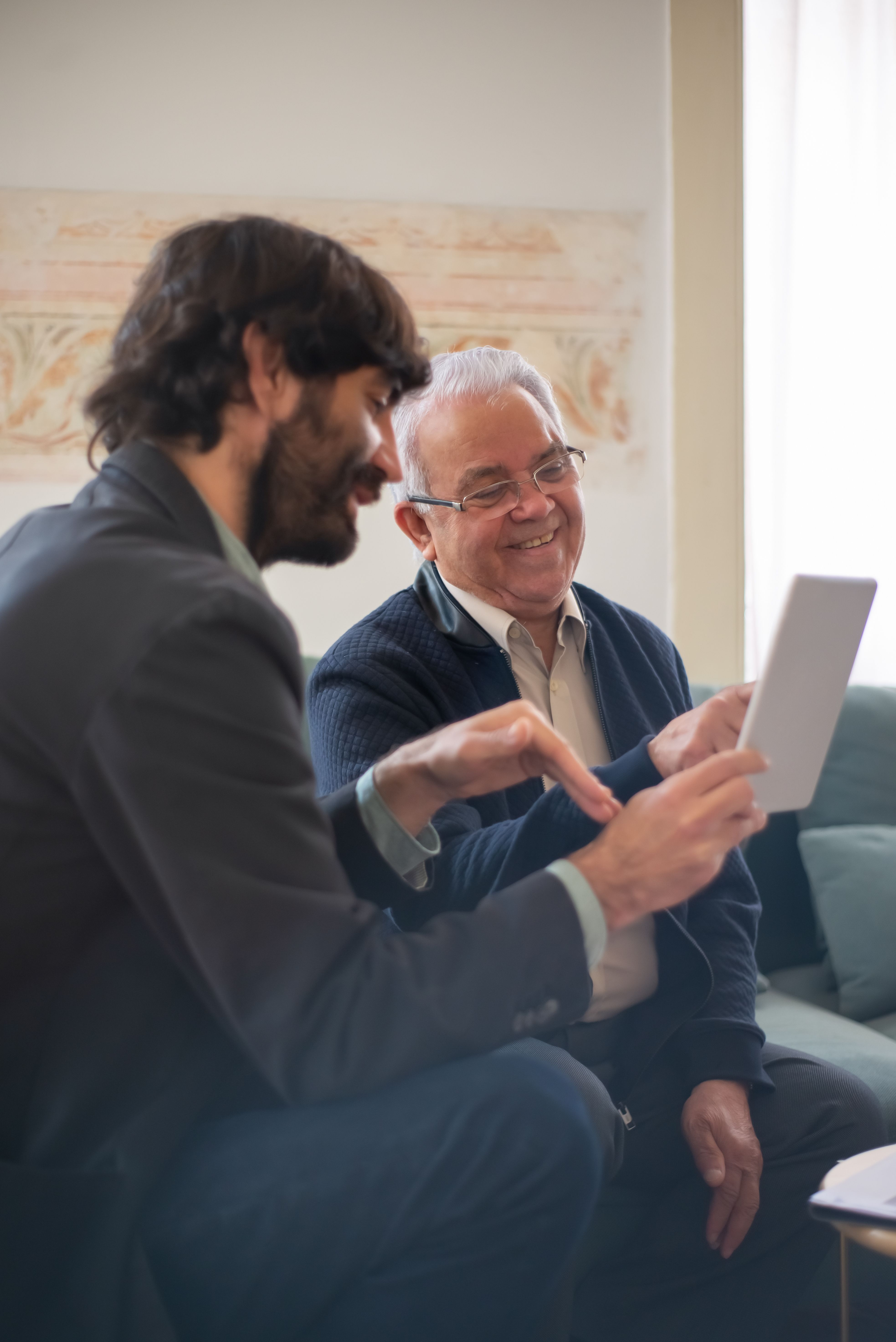 Advisor showing Medicare options on tablet to senior